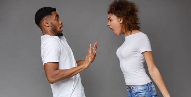 Domestic fight. Angry african-american woman shouting at her man on gray background